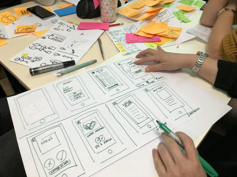 Hand-drawn mobile app wireframes and sticky notes from a design session